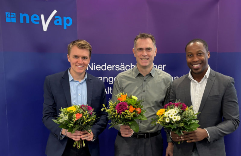 Justin Hoop, Sven Thren und Kelvin Enwemeka stehen vor der NEVAP-Wand